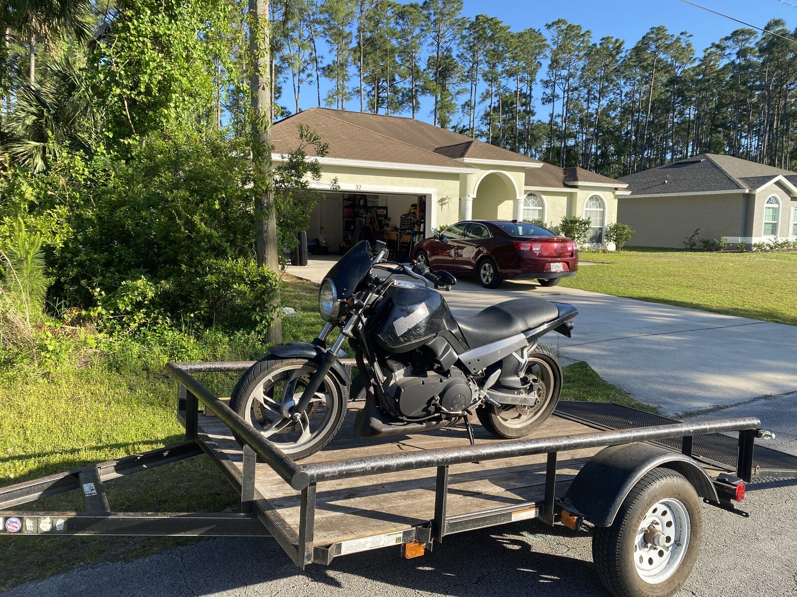A Buell Blast strapped to a borrowed trailer behind a Jeep